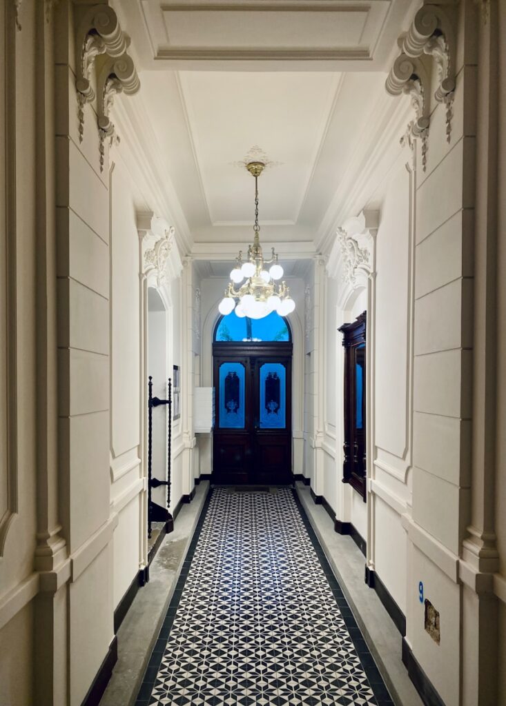 Umzug Wien Neubau – 7. Bezirk: Professionelle Übersiedlung in 1070 Wien 4 a hallway with a blue door and a chandelier