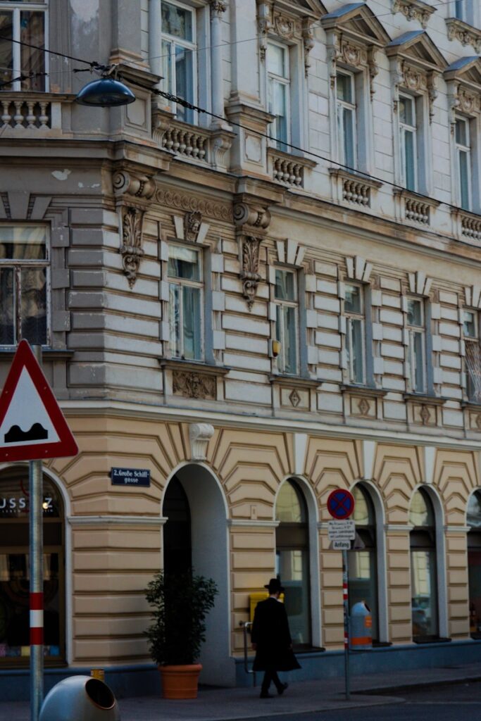 Umzug Wien Neubau – 7. Bezirk: Professionelle Übersiedlung in 1070 Wien 5 a man walking down a street next to a tall building
