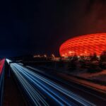 Capture of Allianz Arena illuminated at night with dynamic light trails.