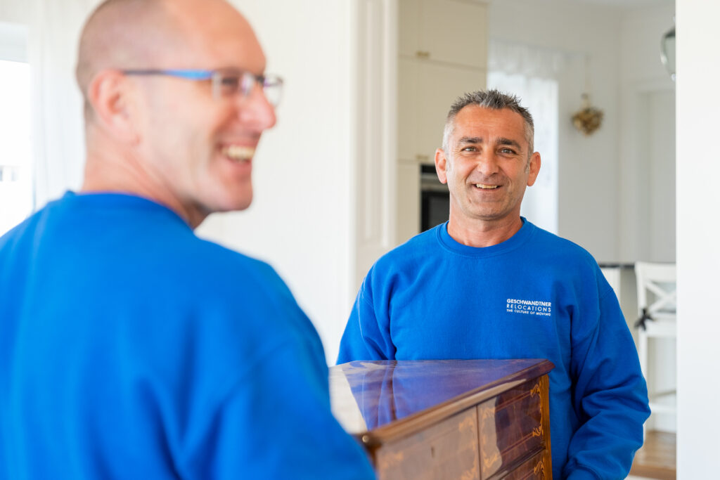 Männer tragen einen Möbelstück.