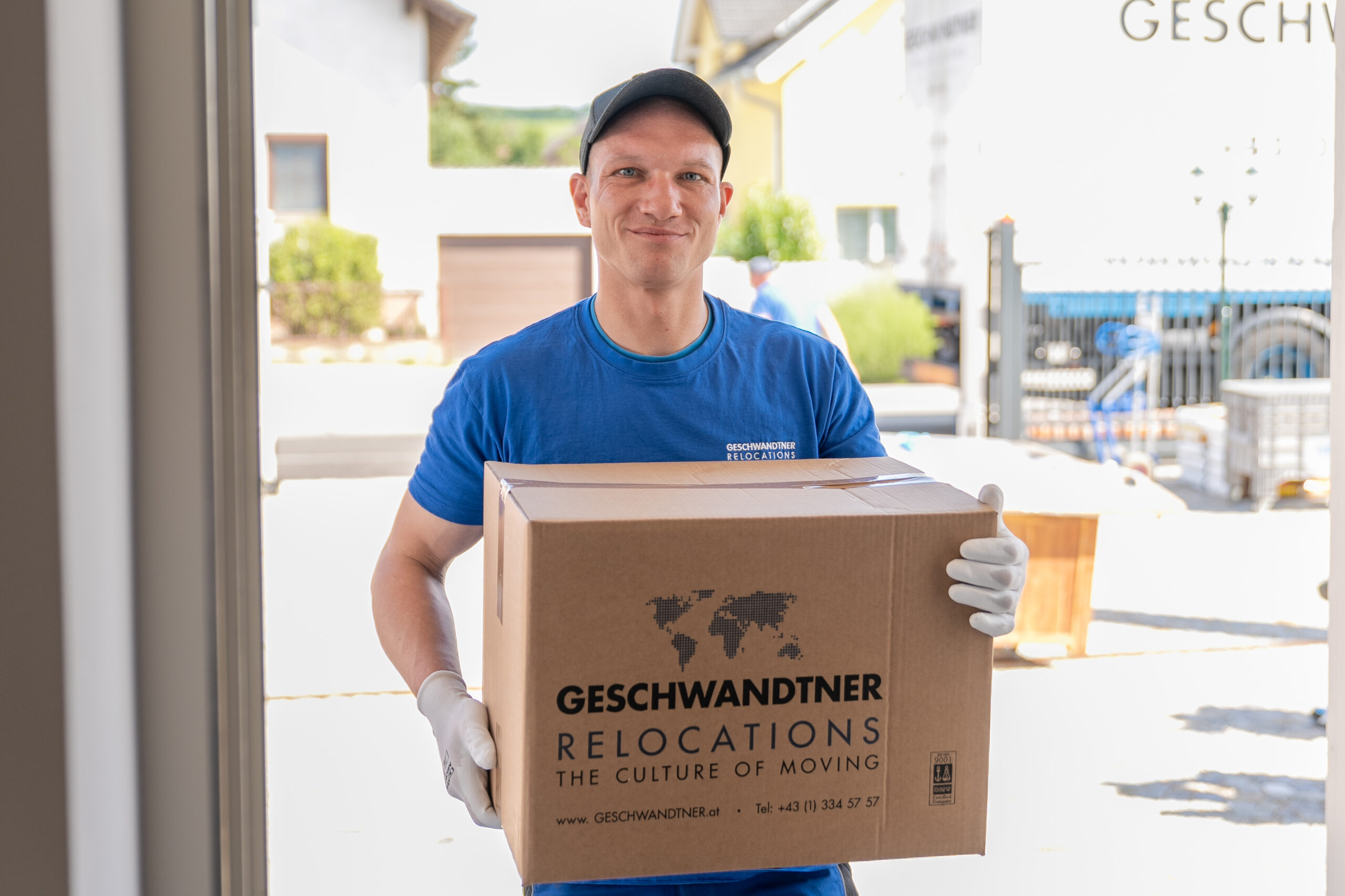 Mann trägt Umzugskarton nach draußen. Büroumzug Wien – zu 100% professionelle Firmenumzüge in Wien