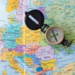 A flat lay image of a compass on a map of Europe, symbolizing travel and direction planning.