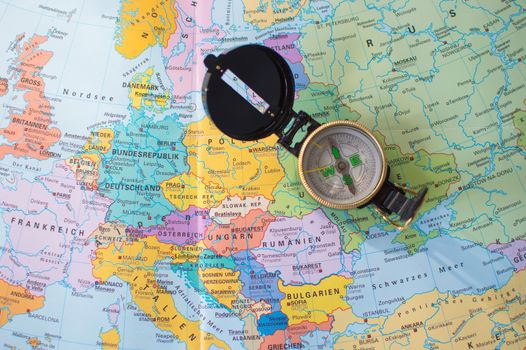 A flat lay image of a compass on a map of Europe, symbolizing travel and direction planning.